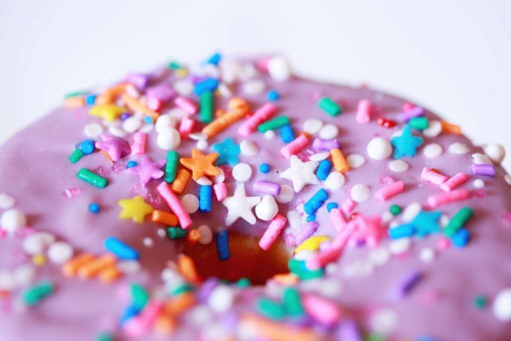 Close-up of a pink frosted donut with colorful sprinkles, symbolizing sugar cravings and emotional eating in the story of why diets never worked for me
